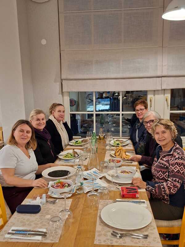 1000014077.jpg A group of women sitting around a dining table.