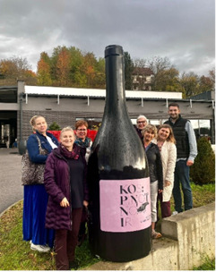 Viinitila.png A group of people standing around a winery sign that resembles a large wine bottle.