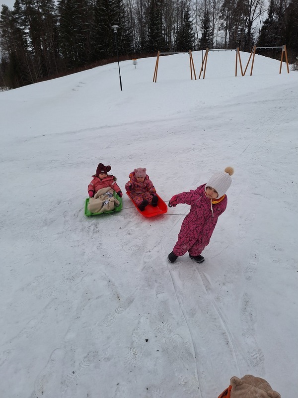 Lapset pulkkaleikissä