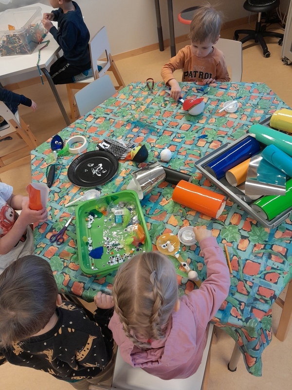 Lapset askartelevat kauhakäsinukkeja