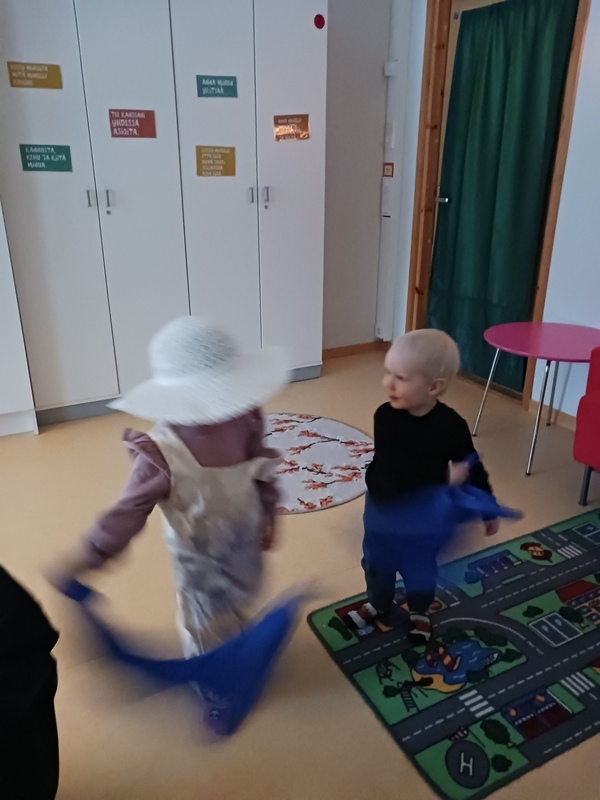 Lapset tanssivat sinisten huivien kanssa
