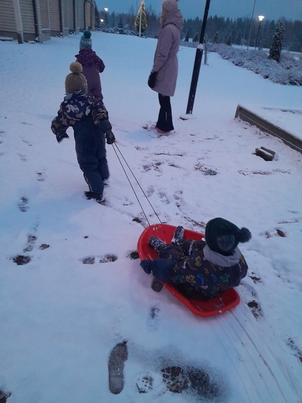 20241203_085217.jpg Lapsi pulkan kyydissä jota toinen lapsi vetää.