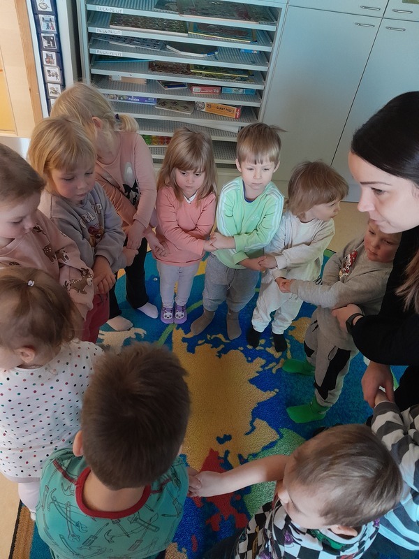 20241211_110625.jpg Lapset seisovat piirissä ja pitävät kädesristissä toisten käsistä kiinni.