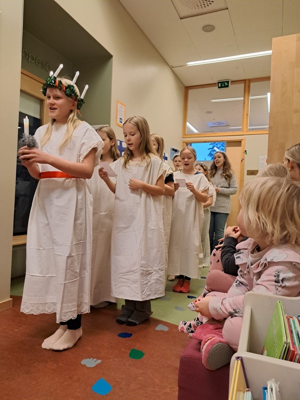 20241213_093717.jpg Lapset seuraavat koululaisten lucia-kulkuetta.