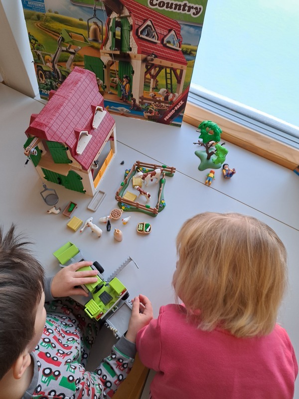 20241216_103427.jpg Lapset leikkivät maatila playmobile leluilla.