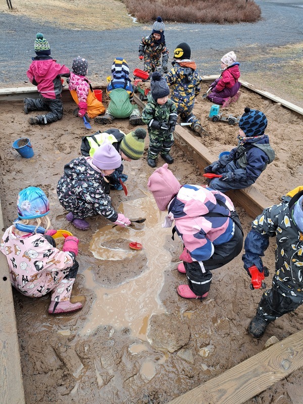 Lapset kuraleikeissä hiekkalaatikolla