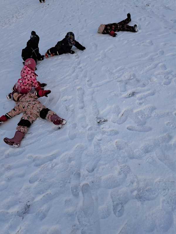 Lapsia tekemässä lumienkeleitä.