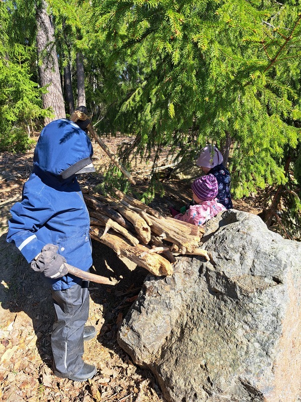 Lapset rakentavat majaa metsässä.
