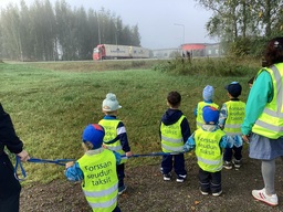 Lapset seuraavat rekka autoja tiellä