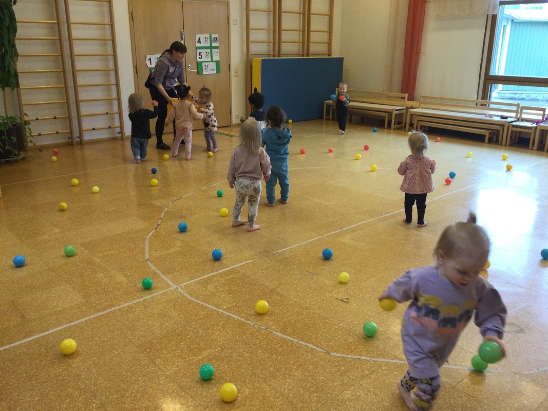 Lapset keräävät palloja jumpalla