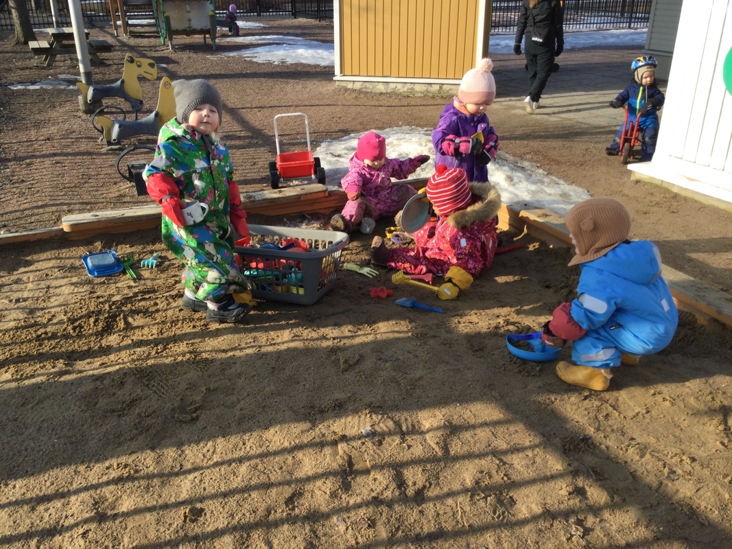 Lapset leikkivät hiekkalaatikolla