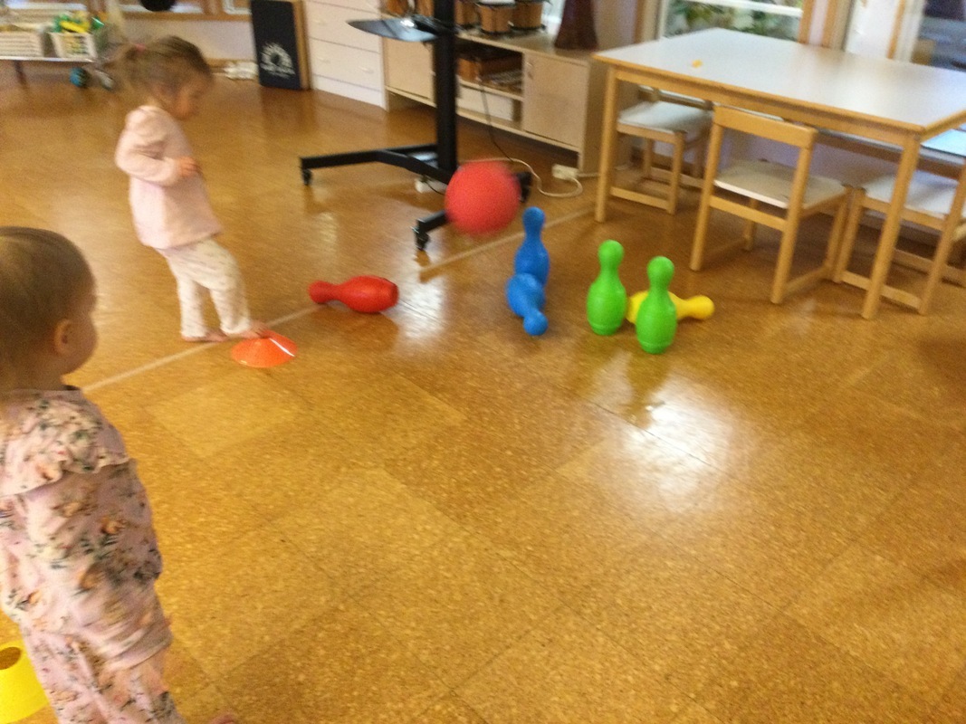 Lapset heittävät palloa keiloja kohti
