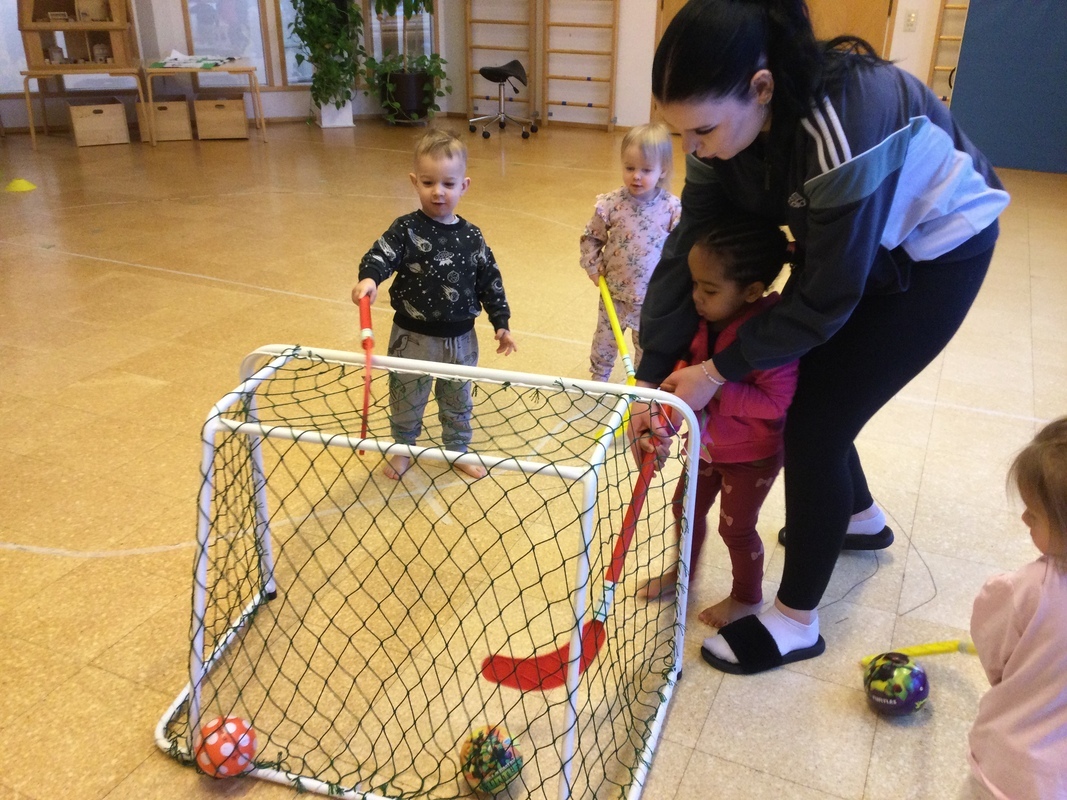 Aikuinen ohjaa lasta mailan käytössä
