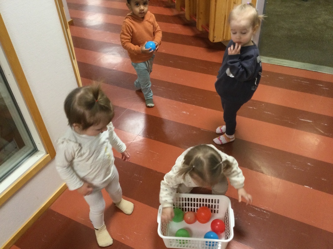 Lapset keräävät värikkäitä palloja