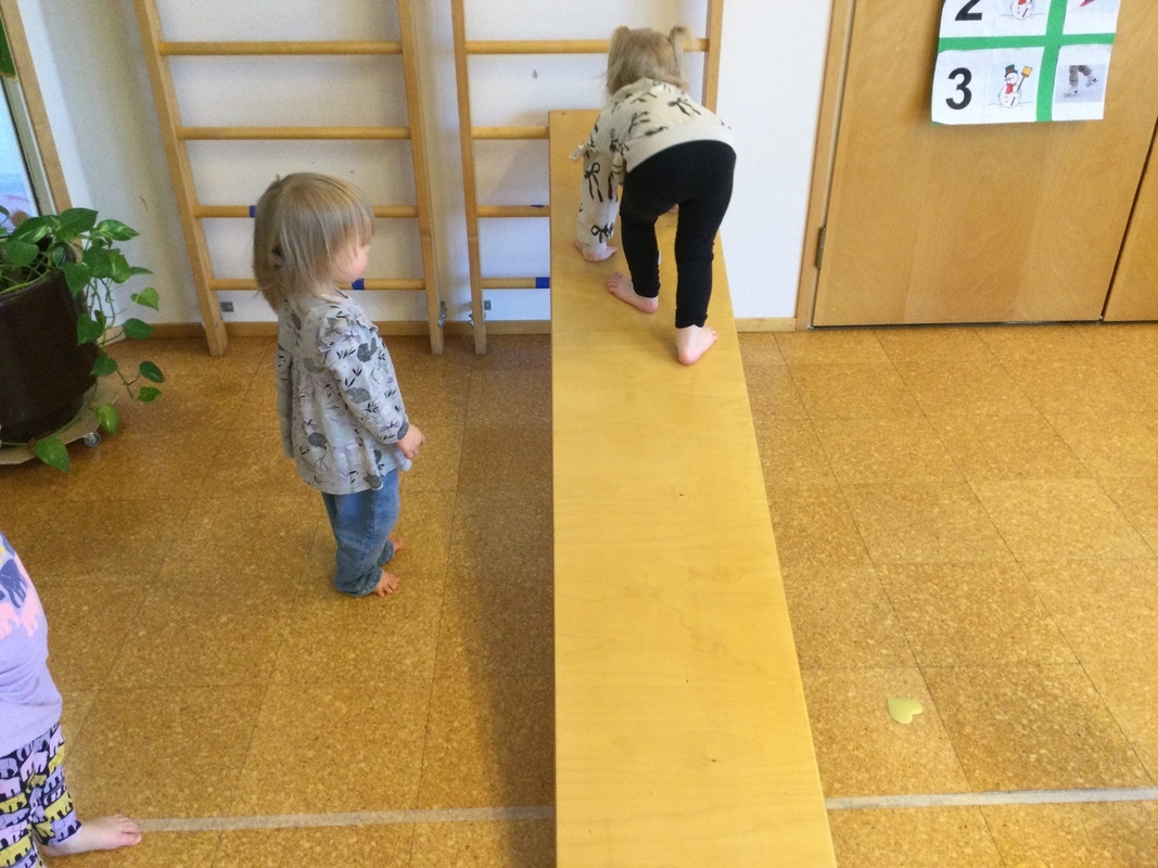 Lapsi kiipeää puulankkua ylös