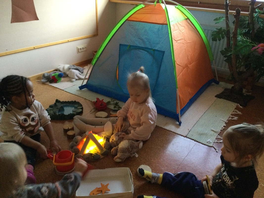 Lapset paistavat kalaa leikkinuotion äärellä