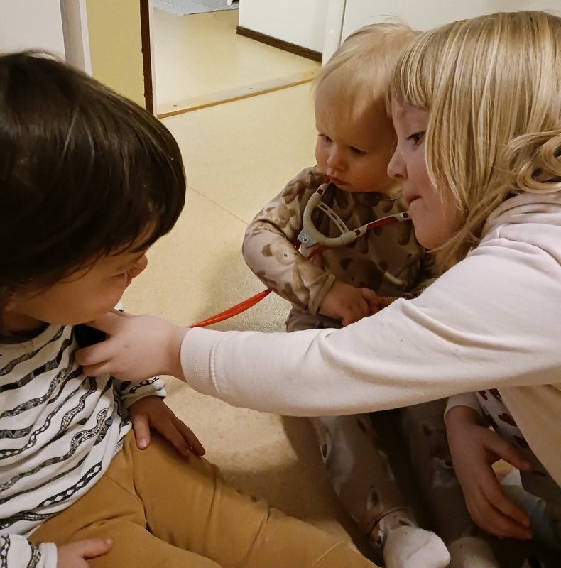Pienempi tutki yhdessä isomman kanssa kaverin sydämenlyöntejä stetoskoopilla. Yhteistyöllä homma sujui hienosti.