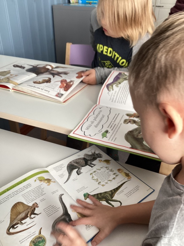 lapsia lukemassa dinosauruskirjoja