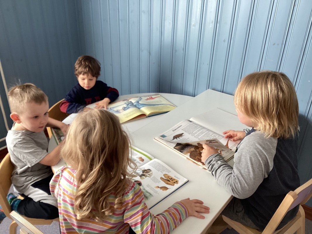 lapsia lukemassa dinosauruskirjoja