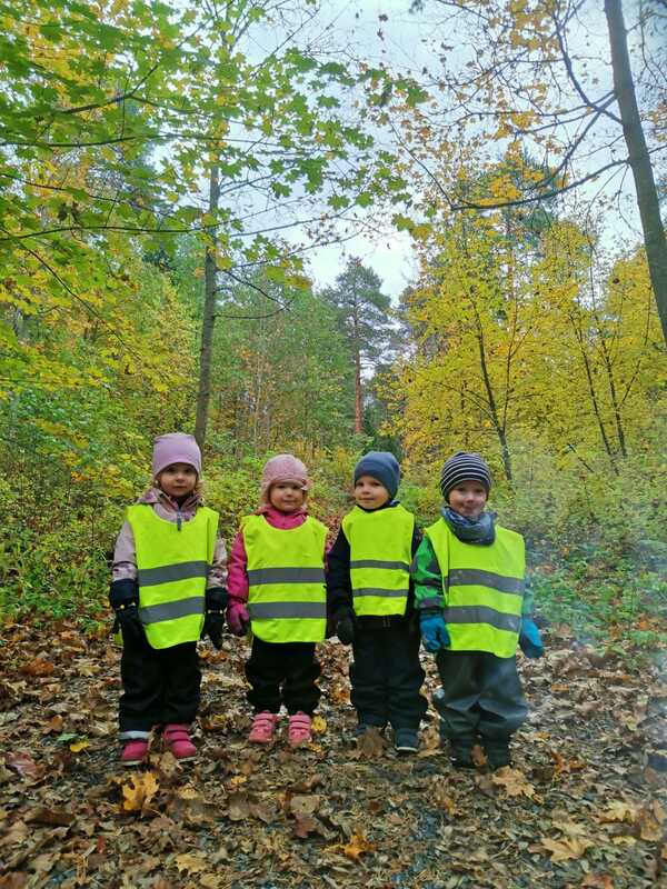 Neljä lasta metsässä iloisina.