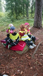 Lapset syövät eväitä metsässä.