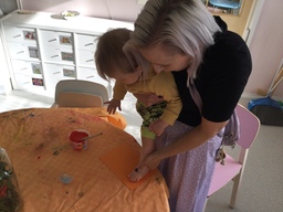 Lapsen oranssiksi maalattu jalkapohja painetaan paperiin, josta tehdään paperiin porkkana.