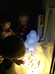 Lapset katsovat lumipallolyhtyä, jossa on valo.