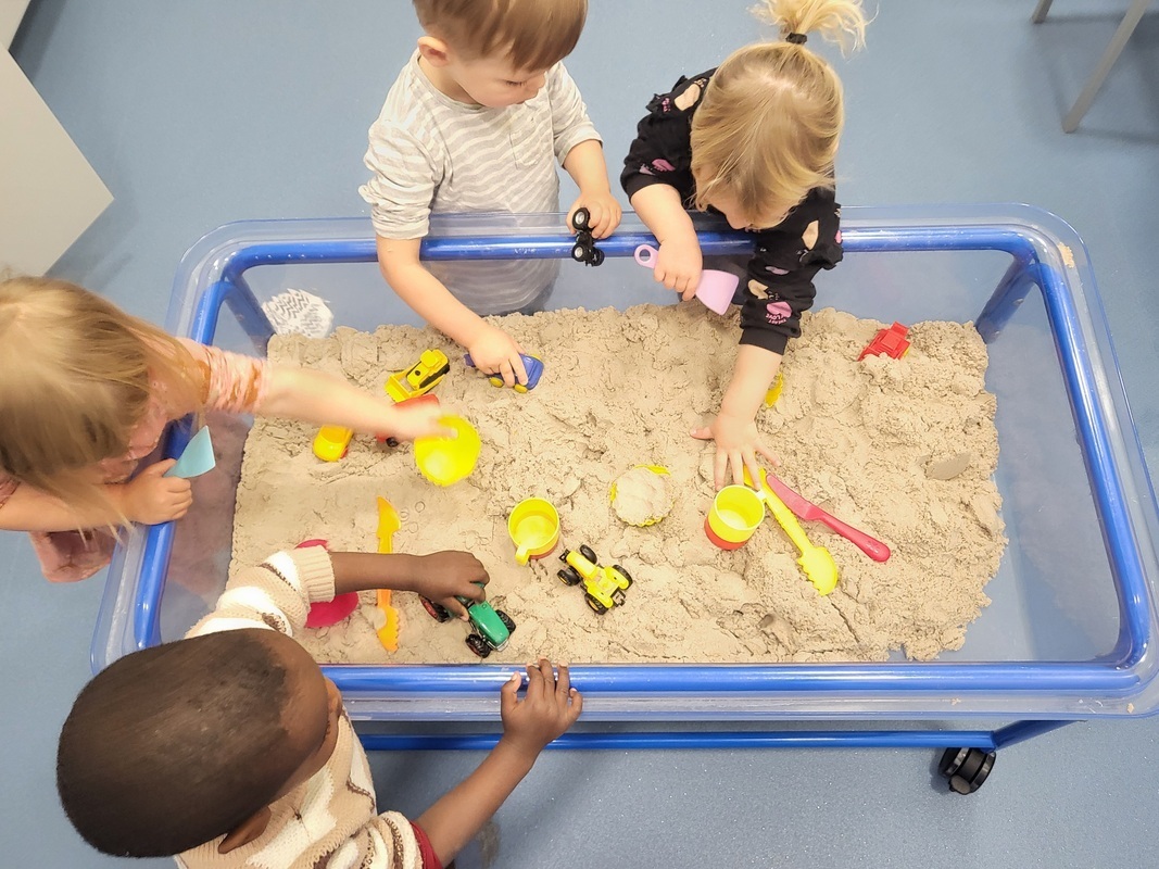 Lapset leikkivät sisällä hiekkaleikissä..