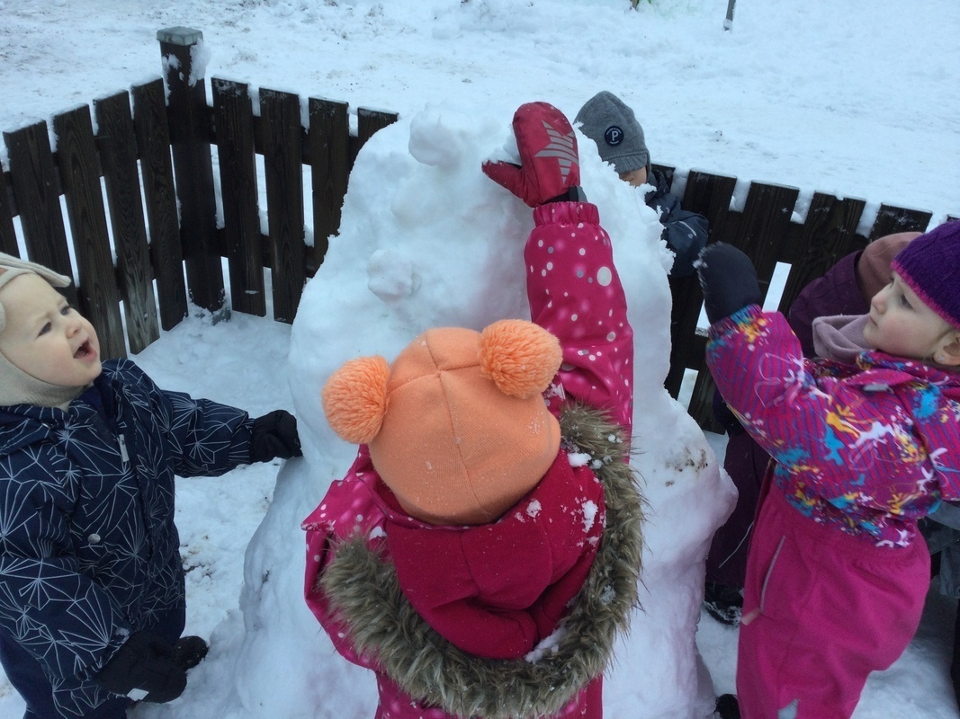 Lapset ihmettelevät lumiukkoa.