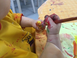 Lapsi kokeilee käsissään pehmeää pensseliä.
