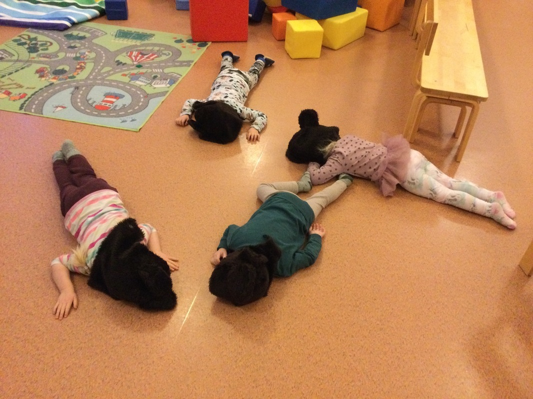 Lapset leikkivät Pikku nalle nukkuu -leikkiä.