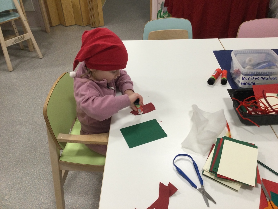 Lapsi askartelee joulukorttia.