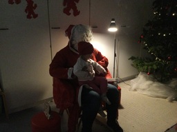 Lapsi istuu joulupukin sylissä.