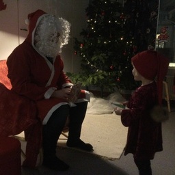 Lapsi juttelee joulupukin kanssa.