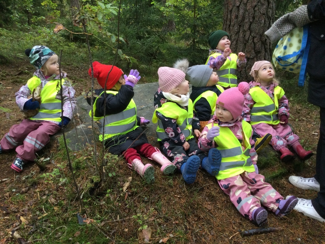 Lapset syövät pientä evästä metsässä.