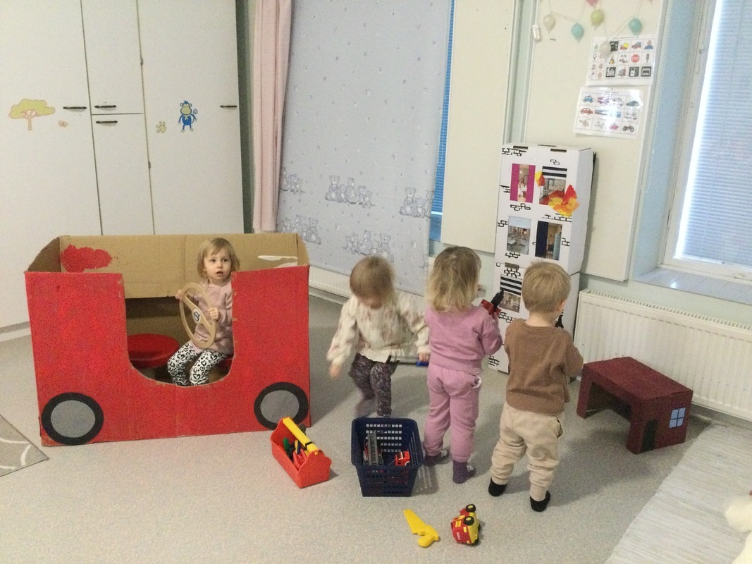 Lapset tutkivat uutta paloautoleikkiä.