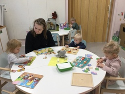 Lapset tekevät palapelejä pöydän ääressä.