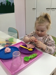 Lapsi muovailee muovailuvahoilla.