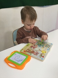 Lapsi puuhailee magneettilelun äärellä.