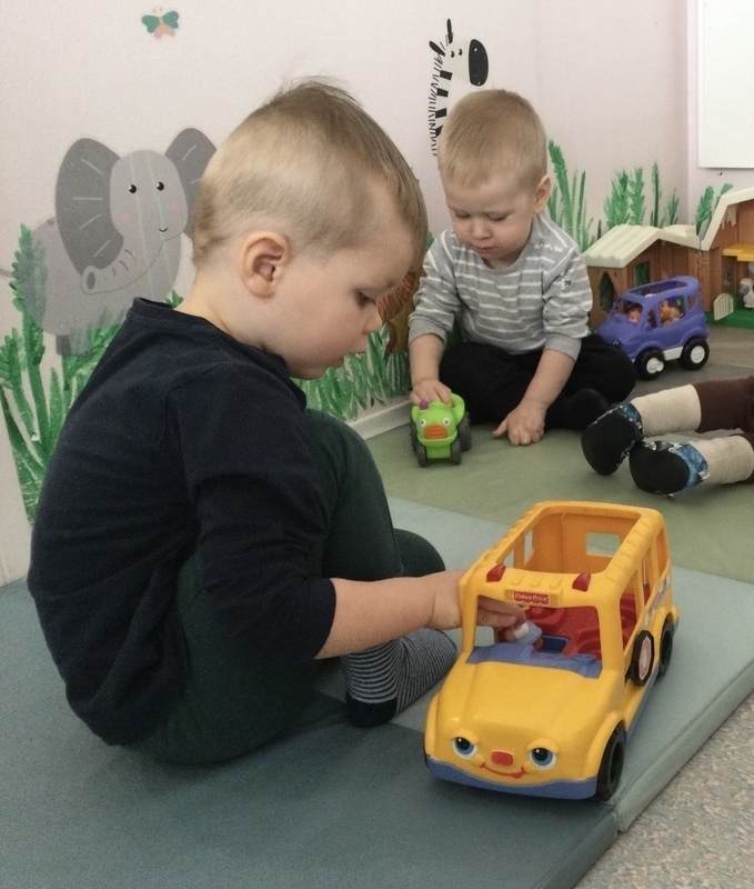 Lapset leikkivät autoilla yhdessä.