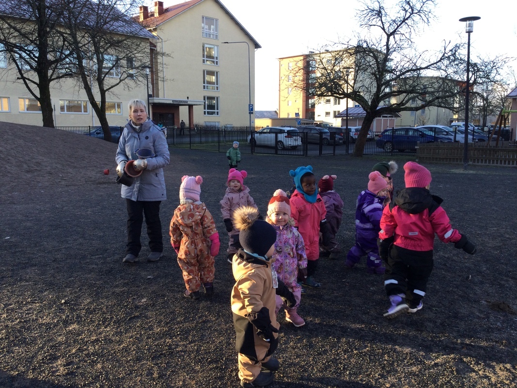 Lapset liikkuvat liikuntaleikkejä pihalla.