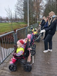 Lapset katselevat sillalla jokimaisemaa.