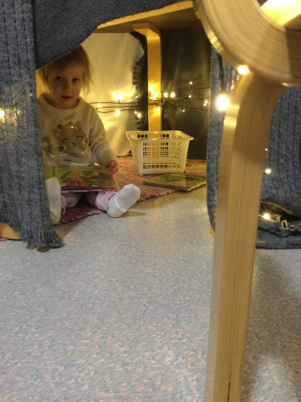 Lapsi lukee kirjaa valomajassa.