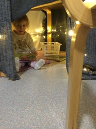 Lapsi lukee kirjaa valomajassa.