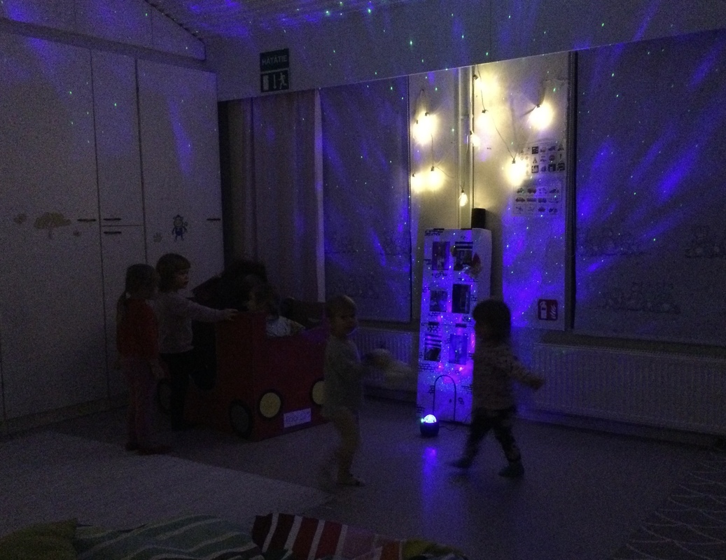 Isot ja pienet lapset leikkivät valomaailmassa.