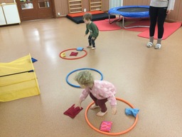 Lapset heittävät hernepusseja vanteiden sisään.