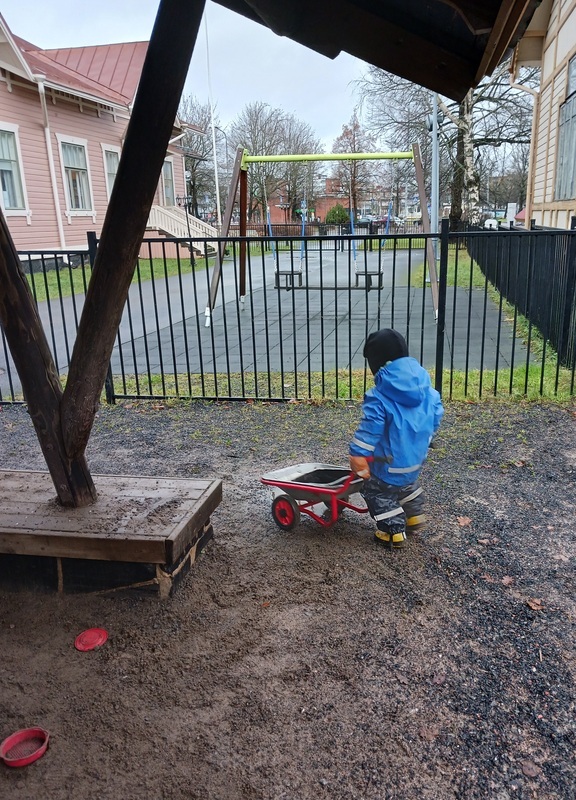 Lapsi työntää kottikärryjä.