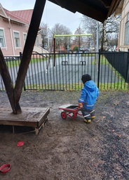 Lapsi työntää kottikärryjä.