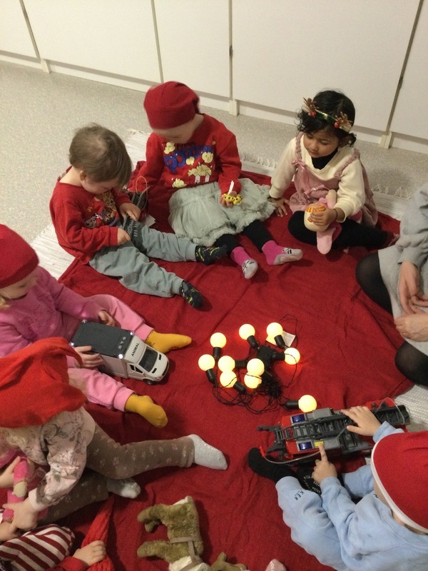 Lapset esittelevät lelupäivän lelujaan istuen piirissä.