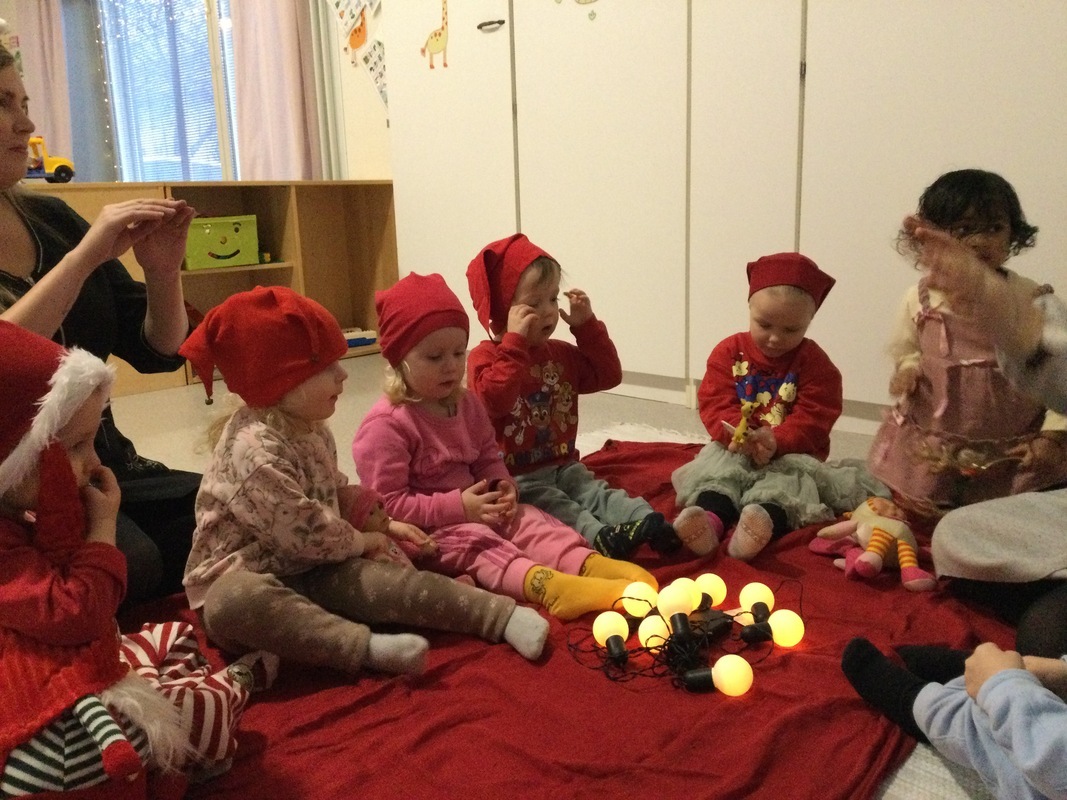 Lapset esittelevät lelupäivän lelujaan piirissä istumalla.